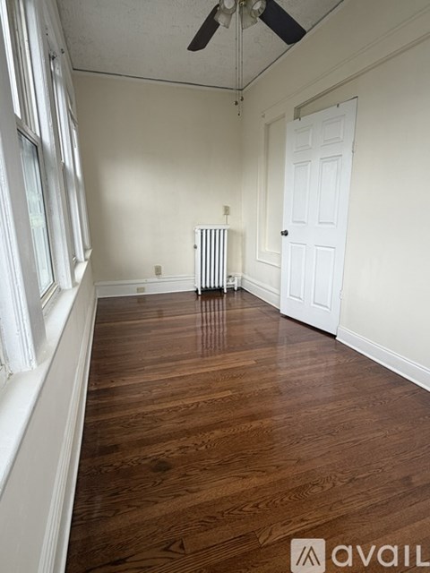 A bedroom with a bed, window, and a speaker.