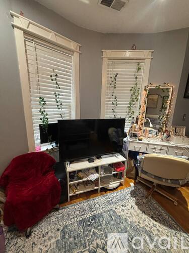 A living room with a television, chair, and a mirror.