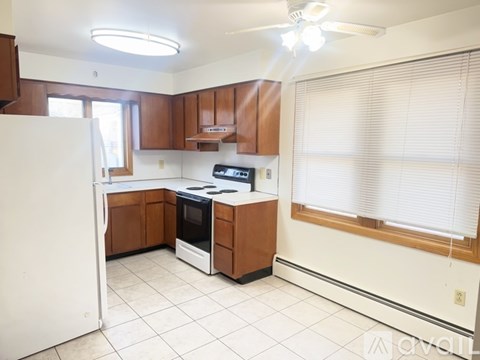 A kitchen with white appliances and brown cabinets.