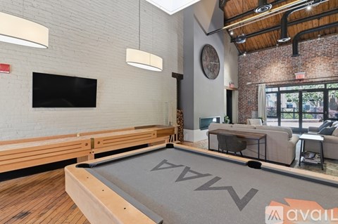 A room with a pool table and a tv on the wall.