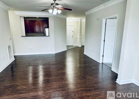 A spacious room with a ceiling fan and wooden flooring.