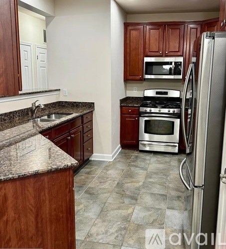 A kitchen with a granite counter top and stainless steel appliances.