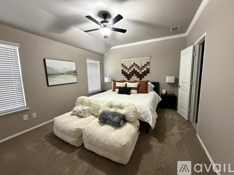 A bedroom with a large bed and a ceiling fan.