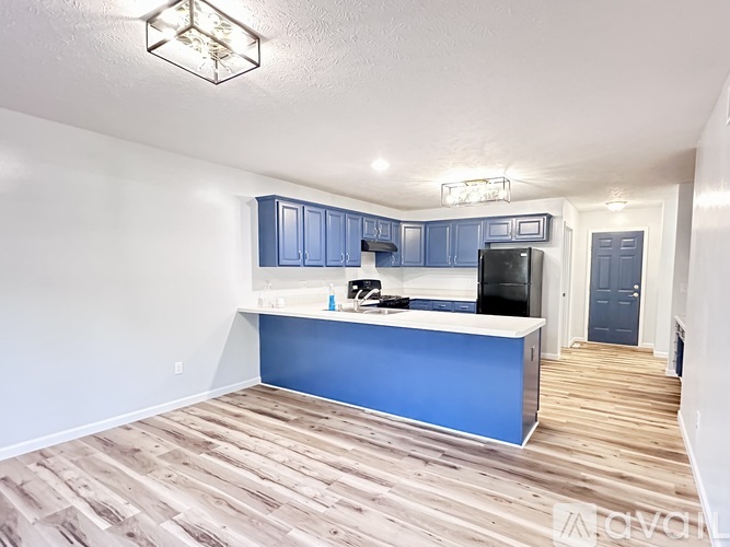A kitchen with blue cabinets and a white counter.