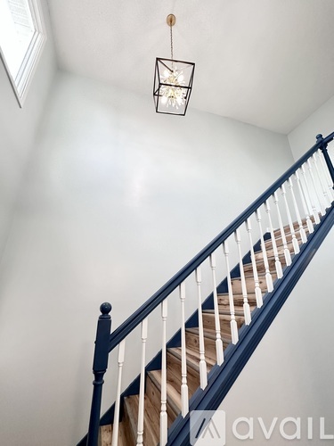 A staircase with a black railing and white balusters.