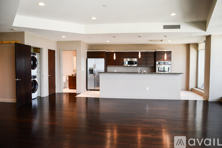 A modern kitchen with dark wood floors and a white countertop.