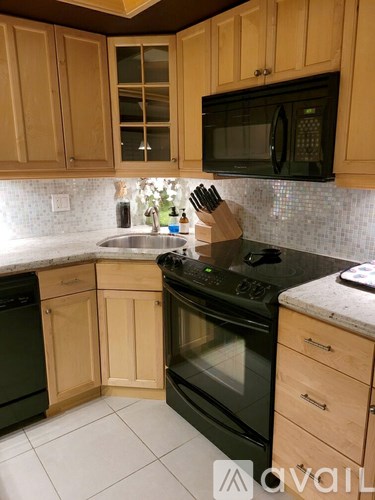 A kitchen with wooden cabinets and black appliances.