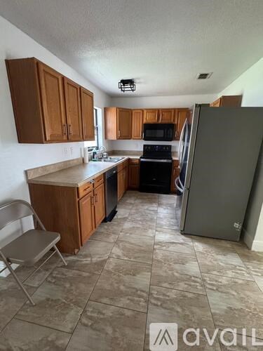 A kitchen with wooden cabinets and a tile floor.