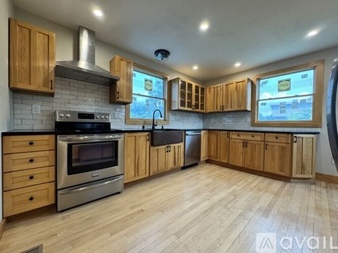 A kitchen with wooden cabinets and a stainless steel oven.