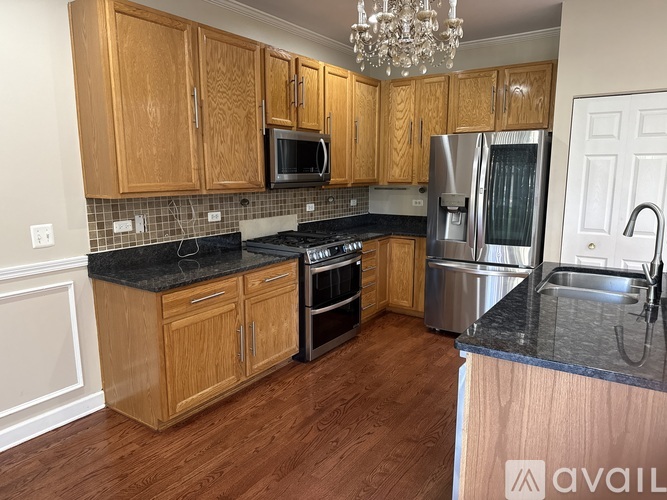 A kitchen with wooden cabinets and a black countertop.