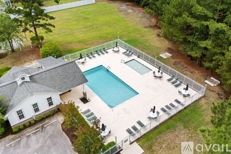 A pool surrounded by a fence and chairs.