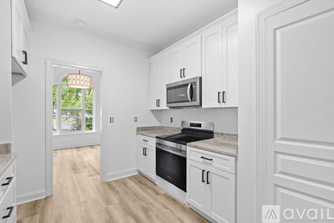 A kitchen with white cabinets and a black stove top oven.