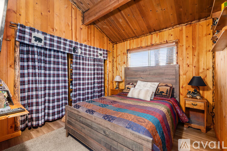 A bedroom with a bed, nightstand, and window.