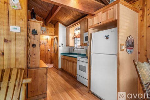 A kitchen with wooden cabinets and a white refrigerator.