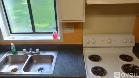 A kitchen with a white stove and a double sink.
