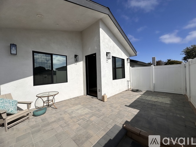 A patio area with a table and chairs outside a house.