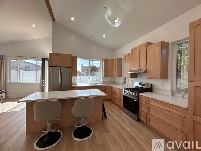 A modern kitchen with wooden cabinets and a central island.