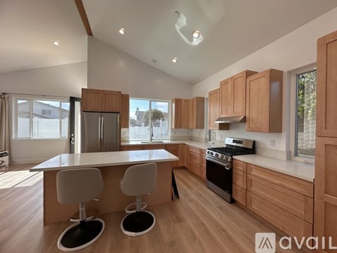 A modern kitchen with wooden cabinets and a central island.