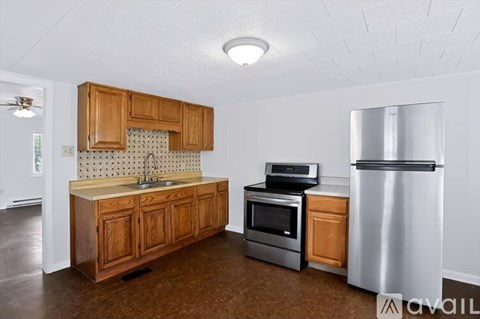 A kitchen with wooden cabinets and a stainless steel refrigerator.