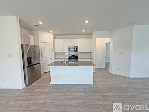 A kitchen with white cabinets and a wooden island.