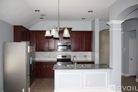 A kitchen with a refrigerator, stove, and sink.