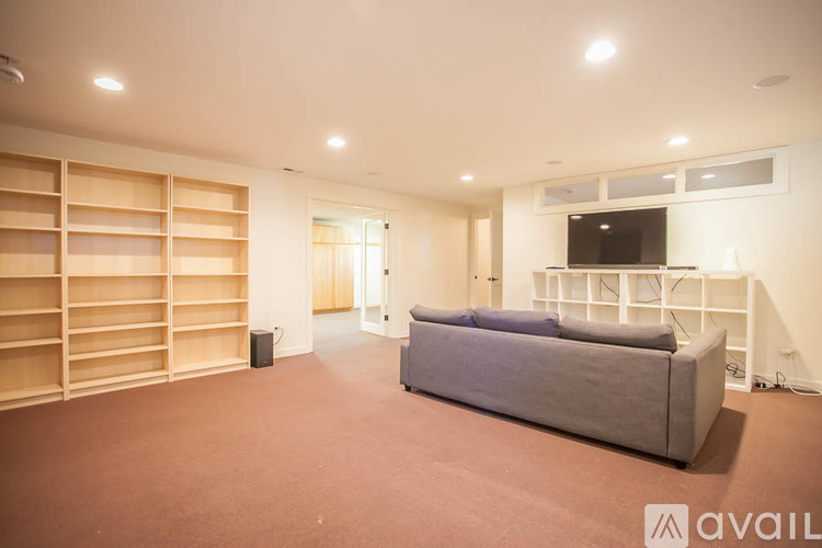 A living room with a grey couch and wooden shelves.