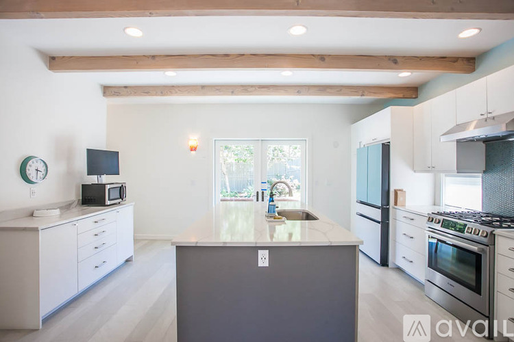 A kitchen with a large island in the middle and a microwave on top.