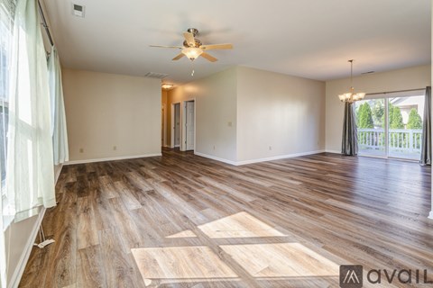 A room with wooden flooring and a ceiling fan.