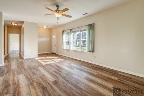 A room with wooden flooring and a ceiling fan.
