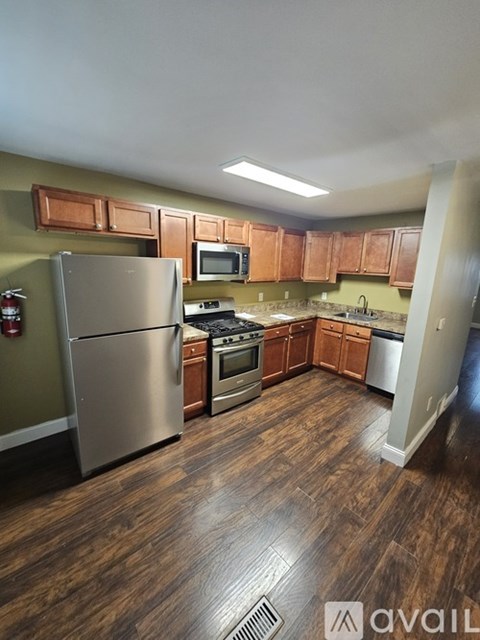 A kitchen with wood floors and stainless steel appliances.