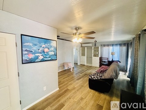 A living room with a television and a bed.