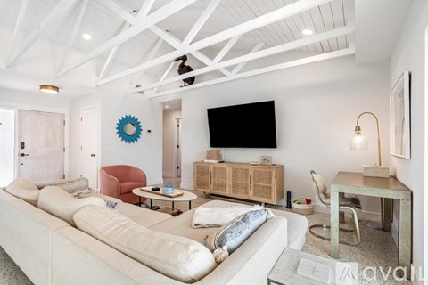 A living room with a white couch and a wooden cabinet.