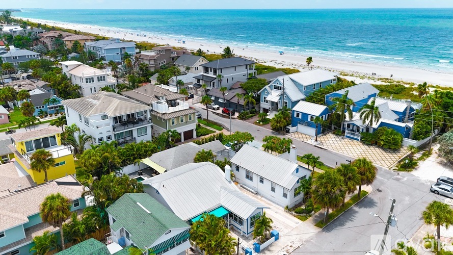 A beachfront community with houses and palm trees.