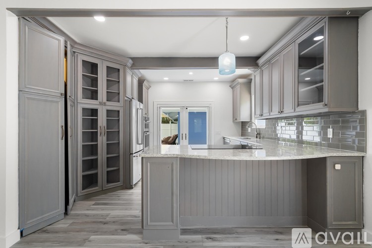 A modern kitchen with grey cabinets and a central island.