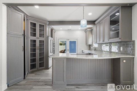 A modern kitchen with grey cabinets and a central island.
