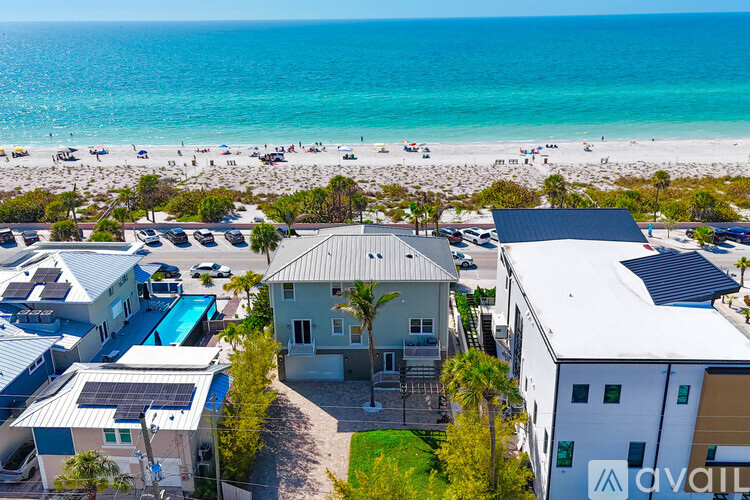 A beachfront property with a swimming pool and a view of the ocean.