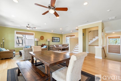 A spacious living room with a dining table and chairs.