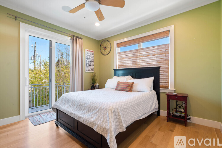 A bedroom with a large bed and a ceiling fan.