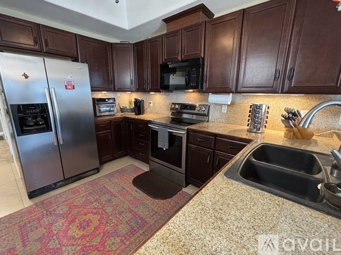 A kitchen with brown cabinets and a granite counter top.