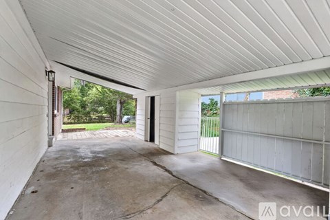 A white covered patio area with a white wall and a white door.