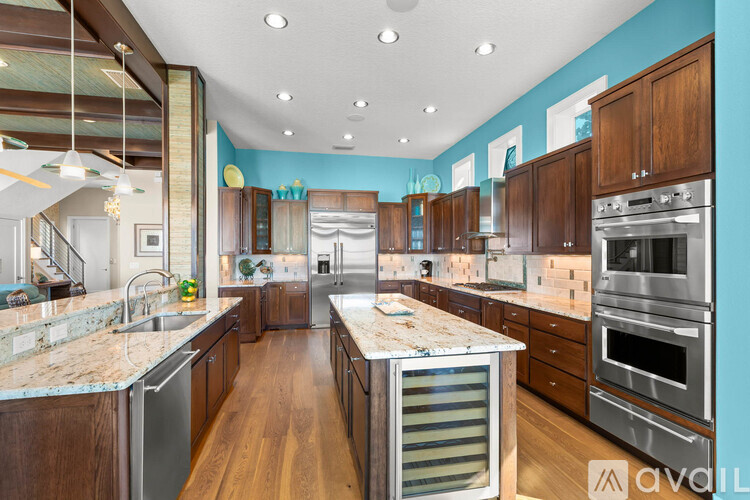 A kitchen with wooden cabinets and a marble countertop.