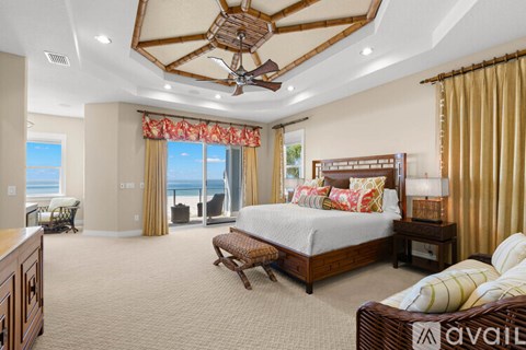 A bedroom with a large bed and a view of the ocean.