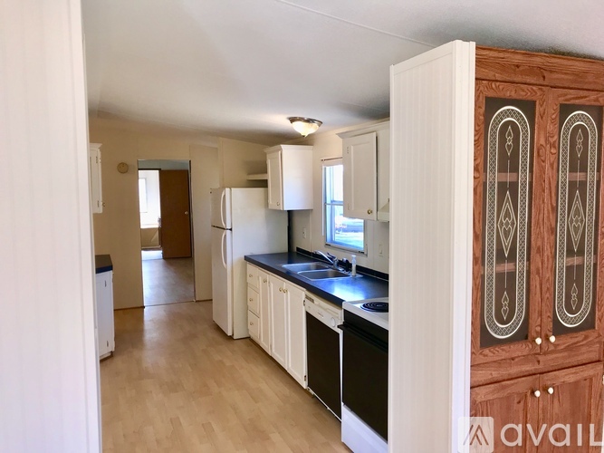 A kitchen with white cabinets and a wooden cabinet.