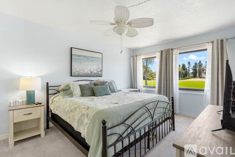 A bedroom with a large bed and a ceiling fan.