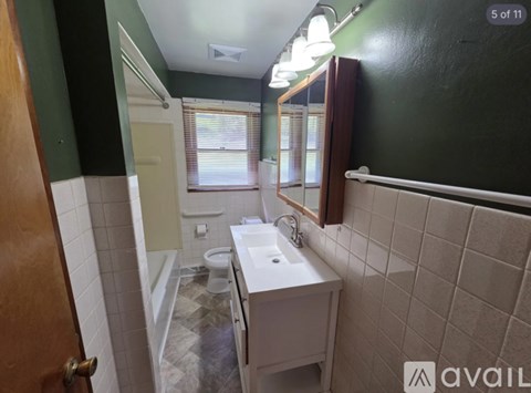 A bathroom with a sink, toilet, and mirror.