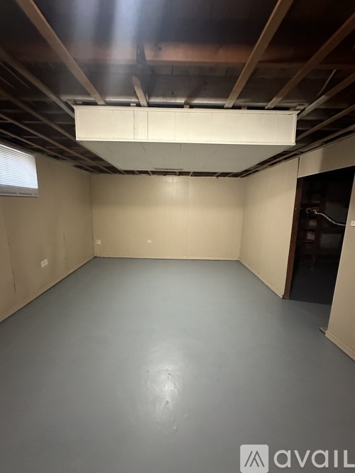 A spacious empty room with a white ceiling and grey floor.