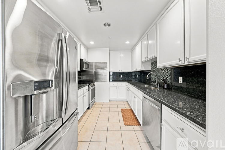 A modern kitchen with stainless steel appliances and white cabinets.