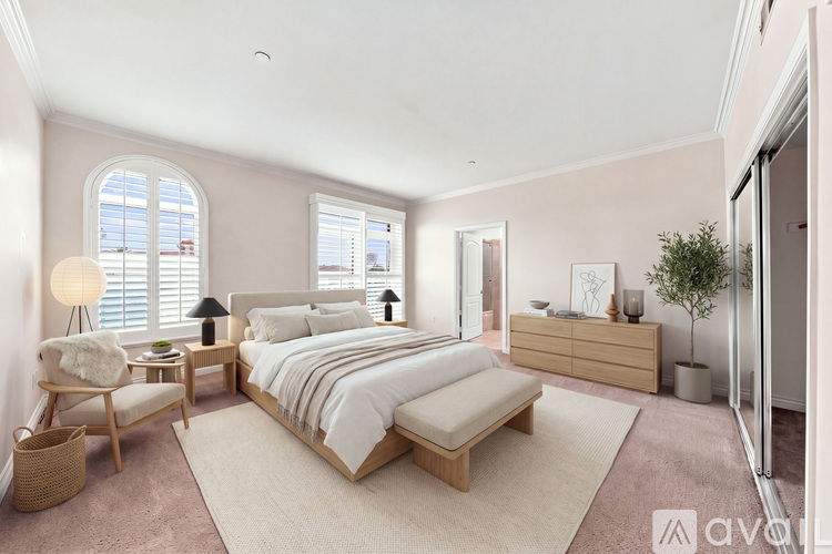 A well-lit bedroom with a large bed and a chair by the window.