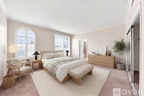 A well-lit bedroom with a large bed and a chair by the window.