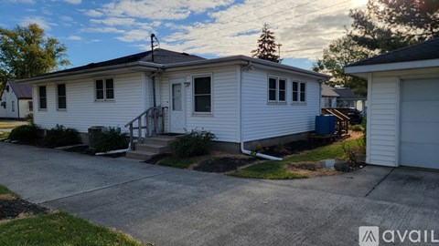 A house with a white exterior and a grey roof is available for rent.
